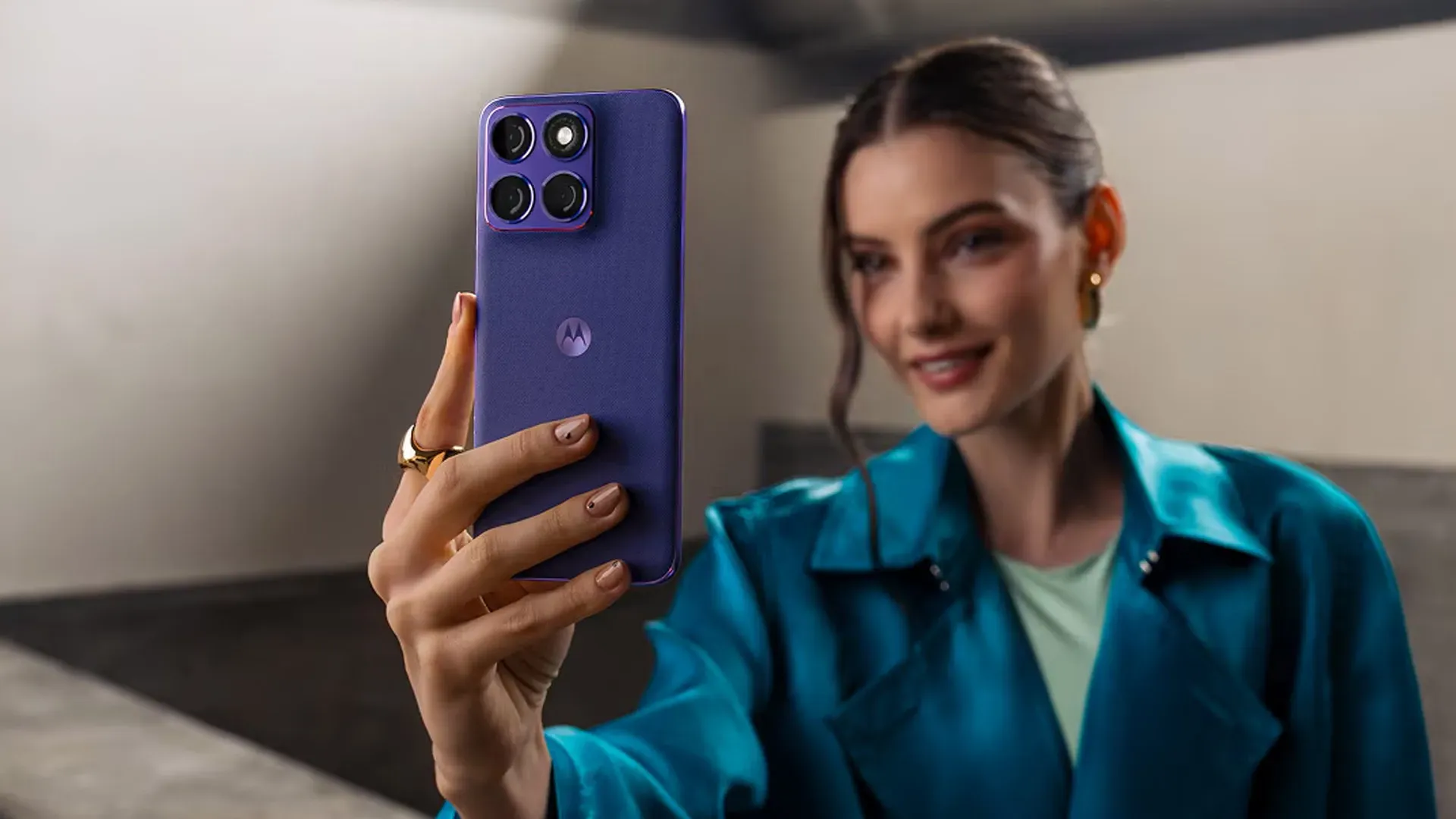 Mulher segurando o Motorola Edge 70 Fusion na cor violeta, mostrando a traseira com o módulo de câmera triplo