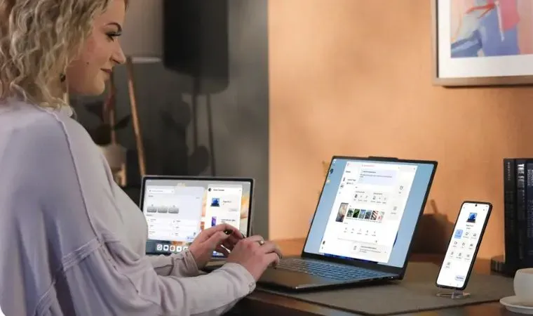 Celular Mulher loira em escritório elegante trabalha com um notebook e com um celular Motorola Signature ao mesmo tempo