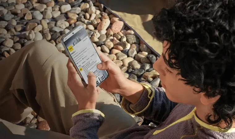 homem sentado no chão mexendo no celular poco x8 pro max