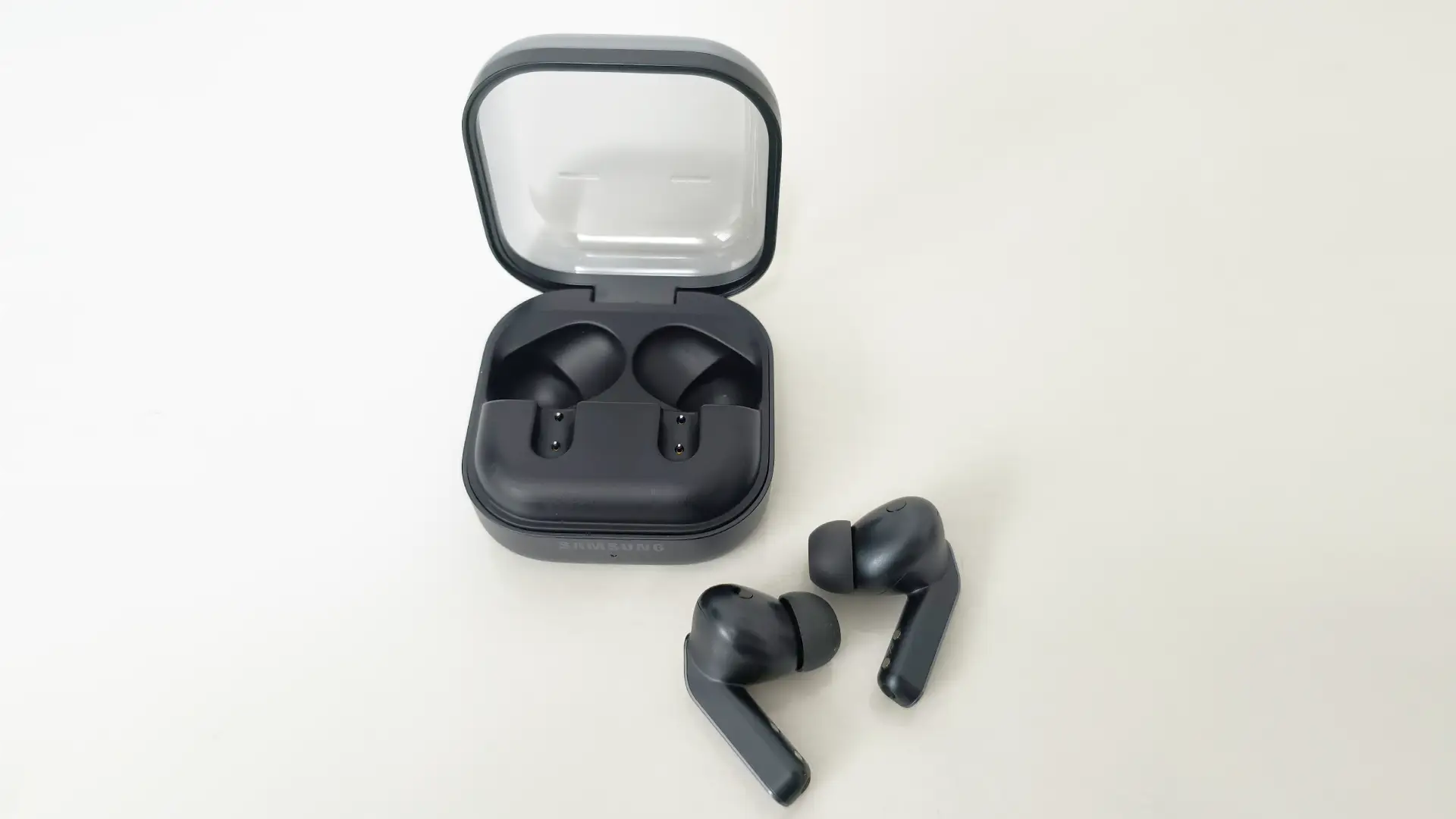 Foto exibindo fones Galaxy Buds4 Pro e estojo de carregamento aberto na cor preta.