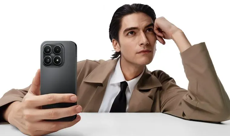 Homem de origem asiática com expressão pensativa, vestindo terno e gravata, segura um celular Xiaomi 17 na mão.