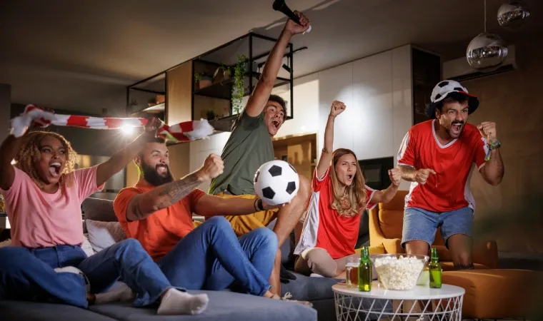 Amigos assistindo a Copa do Mundo na TV da sala de um apartamento