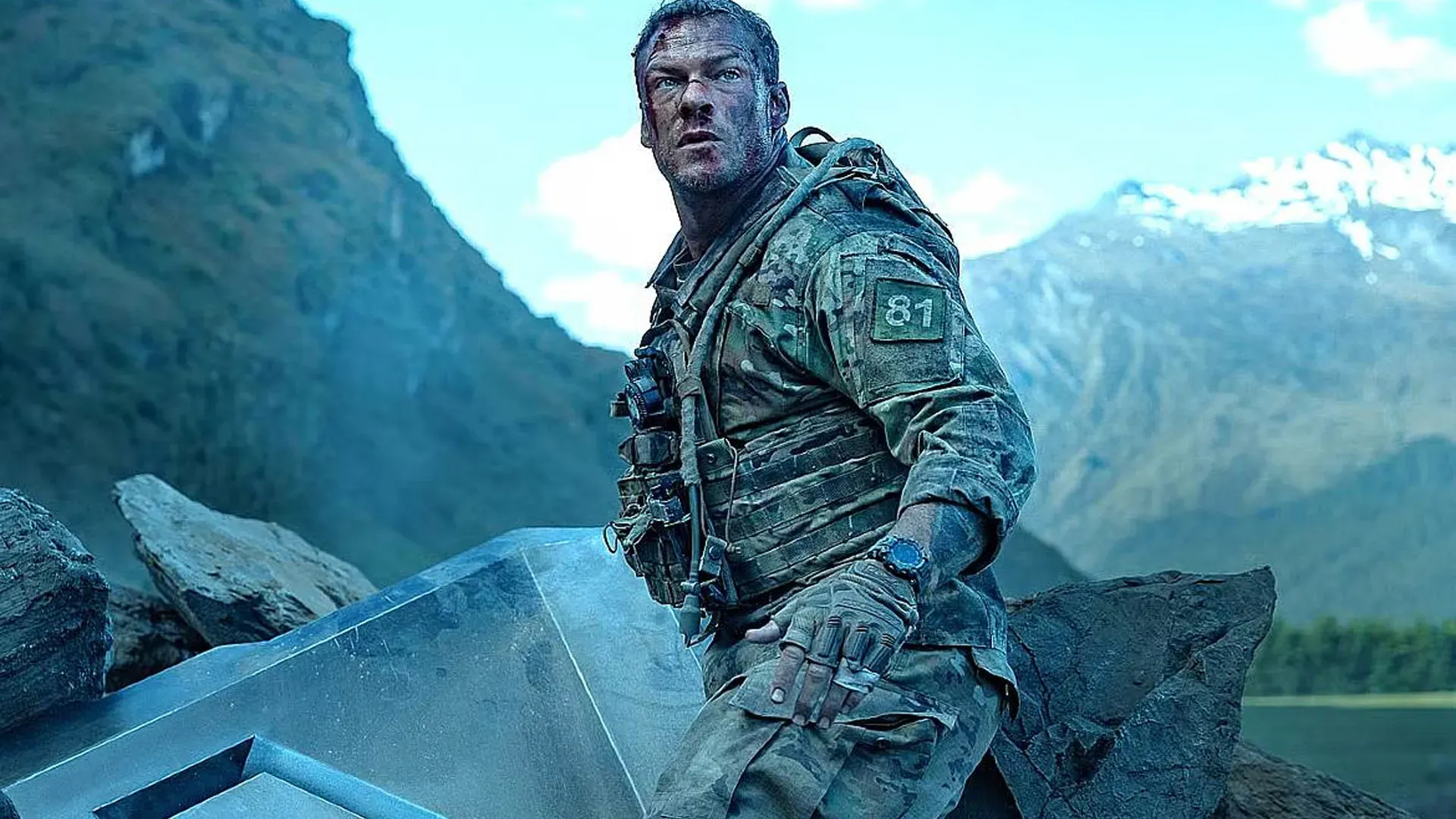 Imagem de soldado com uniforme militar e número 81 apoiado em estrutura metálica no filme Máquina de Guerra