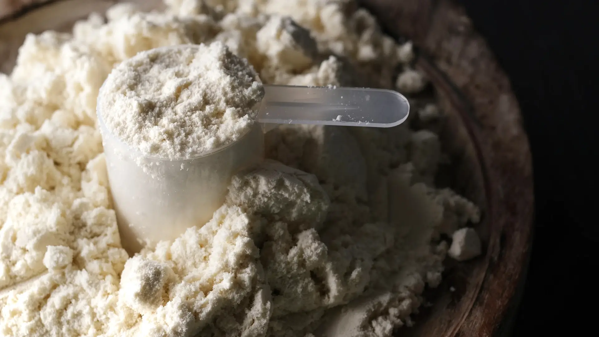 Imagem de um scoop de whey cheio em meio ao whey de baunilha 