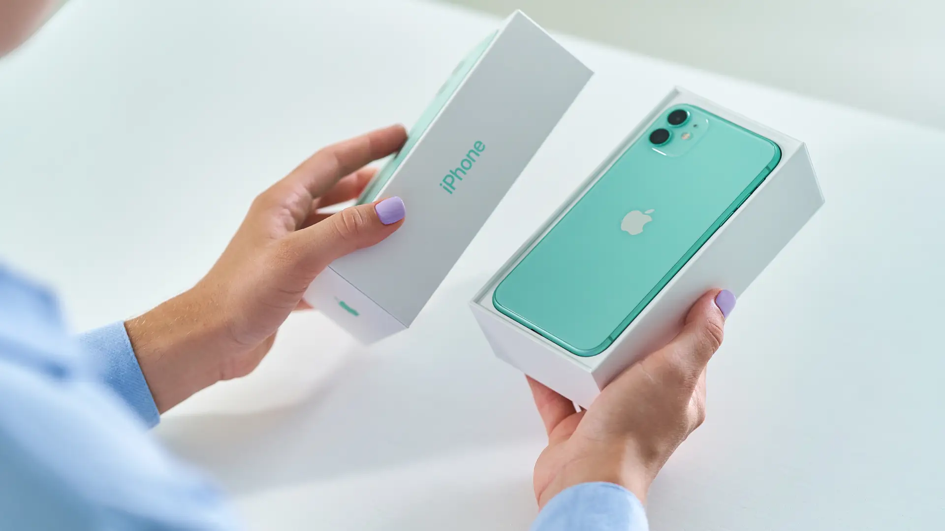 Imagem de uma mulher tirando um iPhone 11 de sua caixa 
