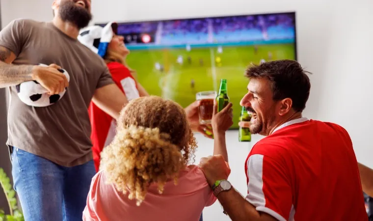 amigos assistindo um jogo da Copa do Mundo na TV da sala