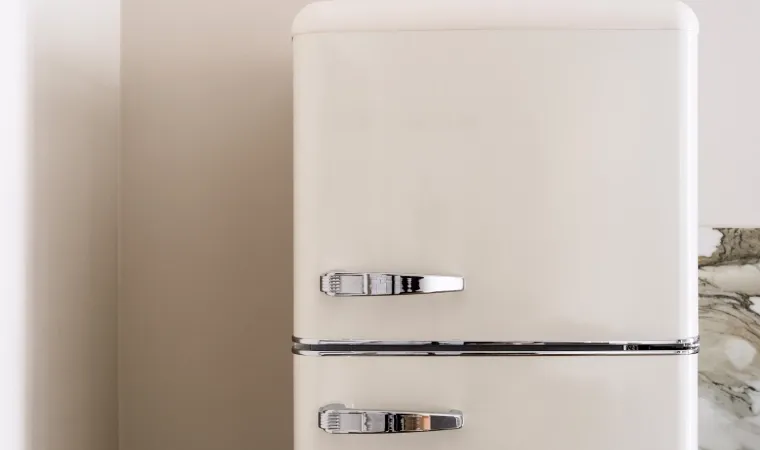 Geladeira duplex retrô em cor creme com acabamento clássico e dois puxadores cromados