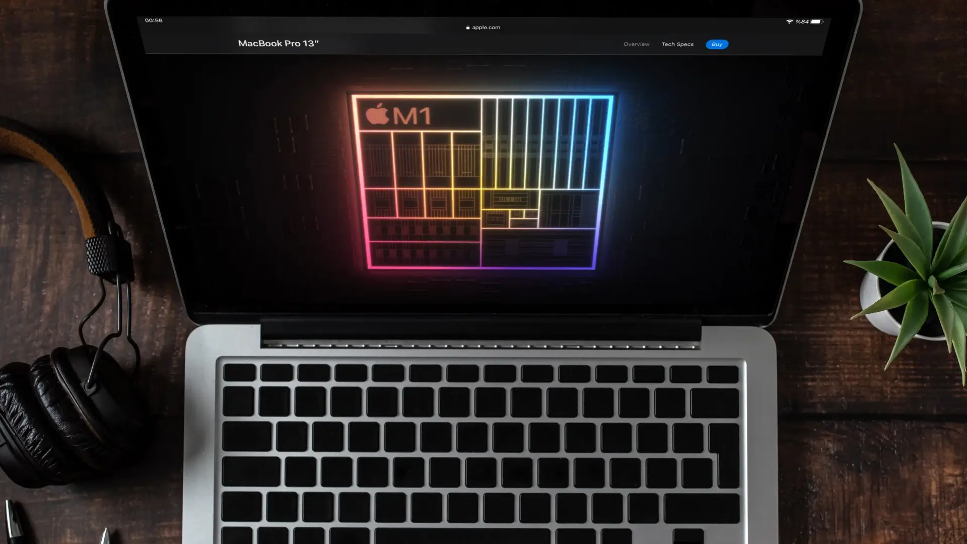 Imagem de um macbook aberto com a tela ligada e em um local com baixa iluminação
