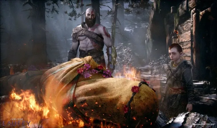 Kratos e Atreus queimando o corpo da personagem Faye Laufey envolto em uma mortalha 