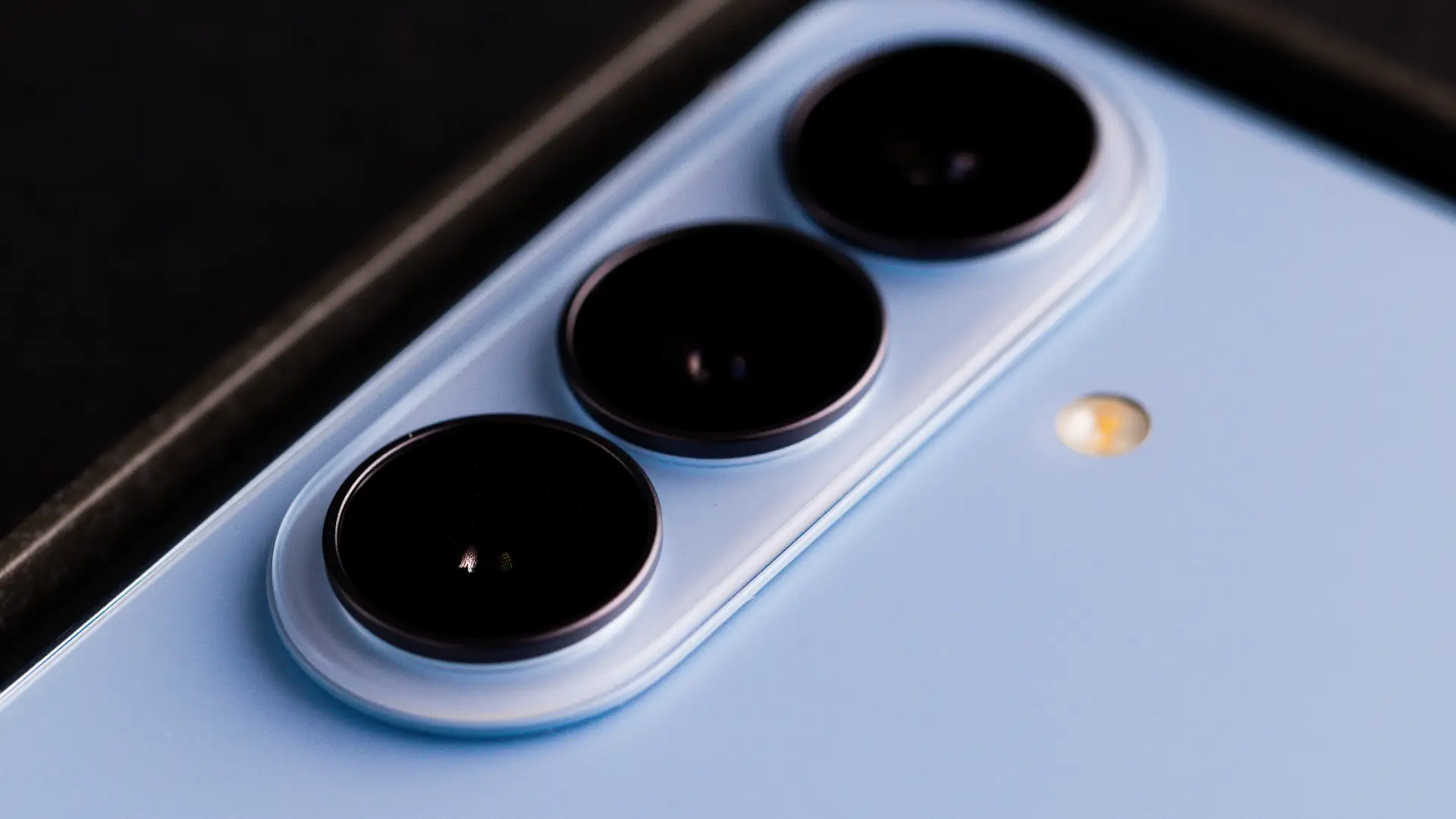 Foto mostra detalhes das câmeras de um telefone de cor azul 