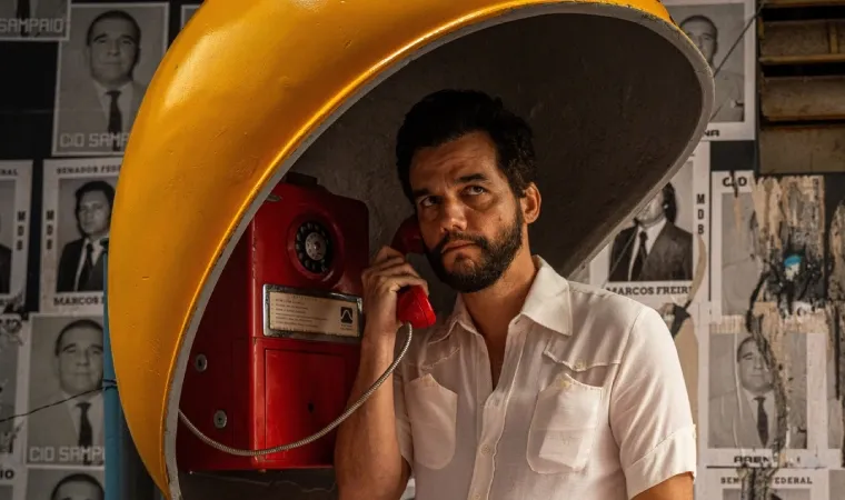 Armando, interpretado por Wagner Moura, fala ao telefone em uma cabine pública.