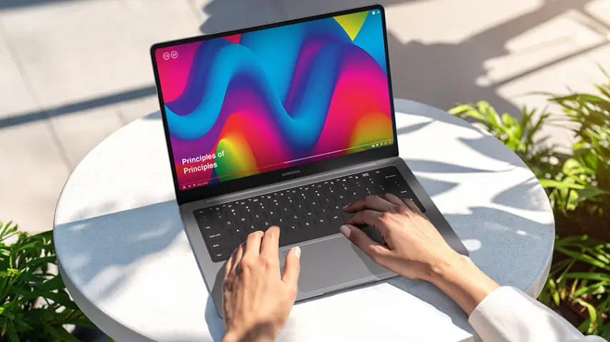 Copilot said: Pessoa usa um Galaxy Book6 Pro sobre mesa ao ar livre, com vídeo colorido em reprodução na tela.