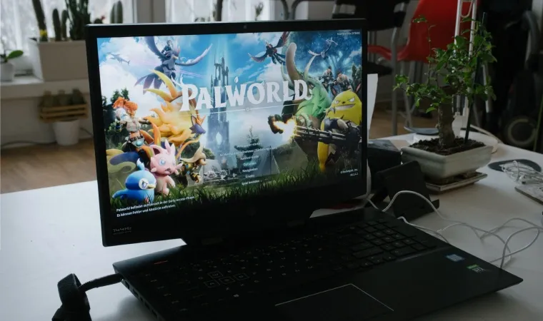 tela do menu inicial do jogo palworld em um notebook em cima da mesa